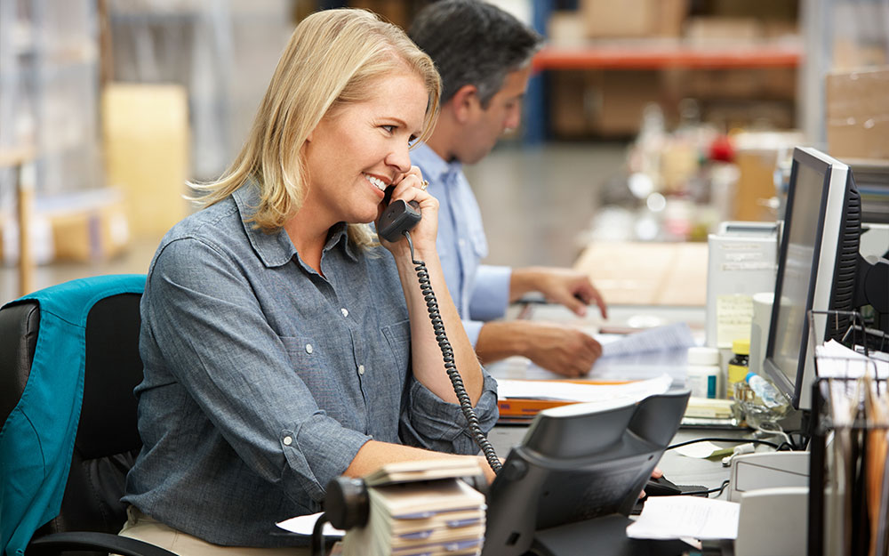 Businesswoman Working At Desk In Warehouse