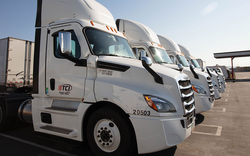 A row of white TCI Transportation Day Cabs